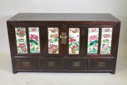 An antique Chinese stained elm side cabinet with two cupboards fitted with folding doors, inset with