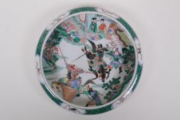 A famille vert porcelain charger with rolled rim, decorated with warriors on horseback, Chinese