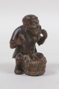 A Japanese carved wood netsuke in the form of a man making mochi, 5cm high