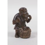 A Japanese carved wood netsuke in the form of a man making mochi, 5cm high