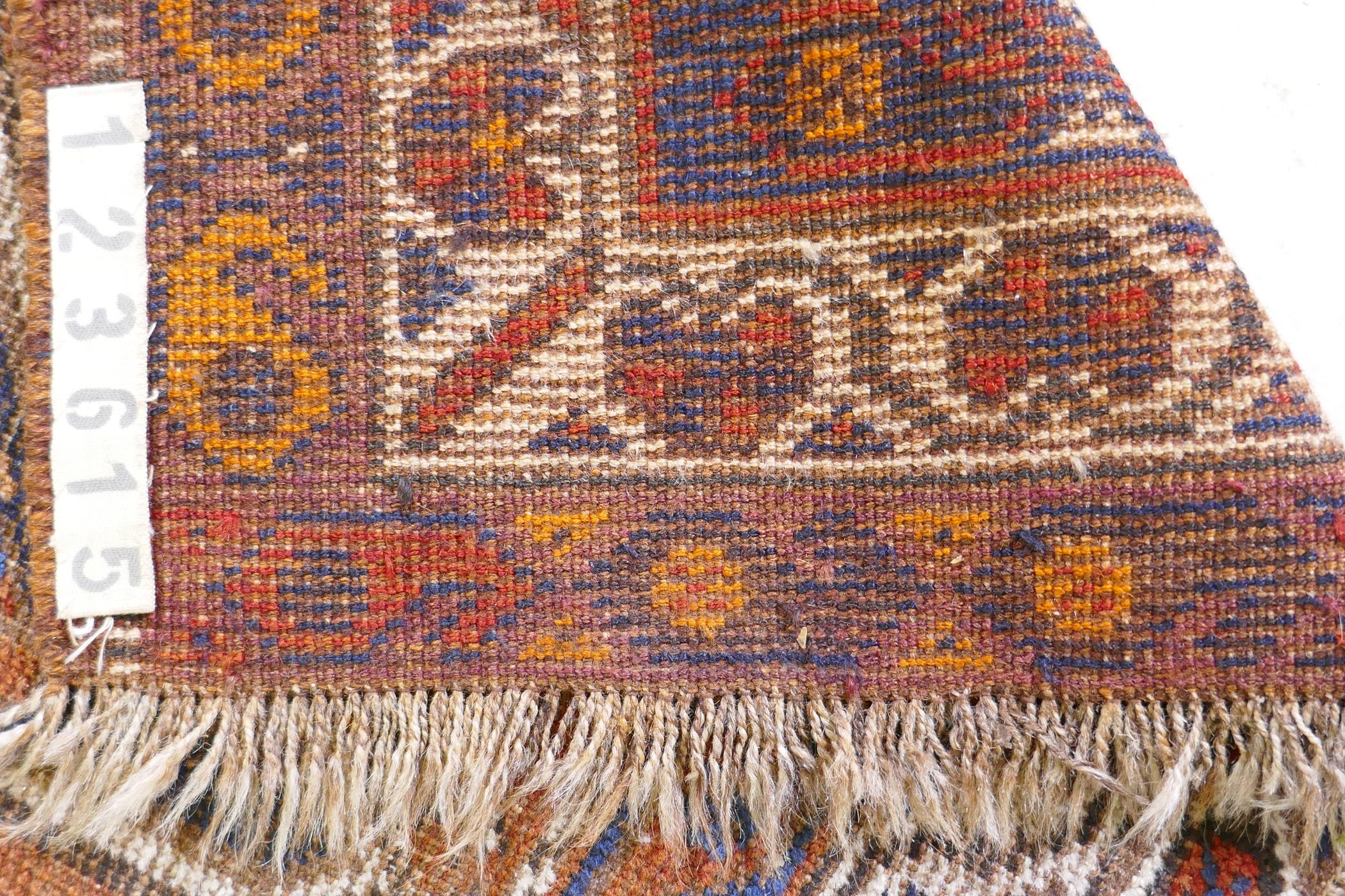 An antique terracotta ground Persian wool village rug, with a twin geometric medallion design, AF, - Image 5 of 5