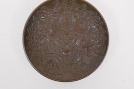 A Chinese bronze trinket dish with raised dragon and flaming pearl decoration, impressed 4 character