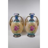 A pair of Edwardian porcelain vases with gilt handles and floral decoration, 44cm high, AF