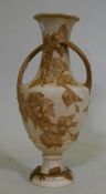 A Royal Dux two handled amphora vase, with raised floral parcel gilt decoration on a buff glaze,