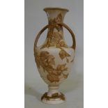 A Royal Dux two handled amphora vase, with raised floral parcel gilt decoration on a buff glaze,