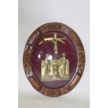 A brass plaque depicting the Pieta, housed in carved oak frame with convex glass, 51cm high