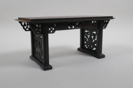 A Chinese carved and pierced hardwood stand in the form of a miniature altar table, 22cm wide