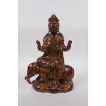 A Chinese coppered bronze of Quan Yin seated upon an elephant with the remnants of gilt patina, 32cm