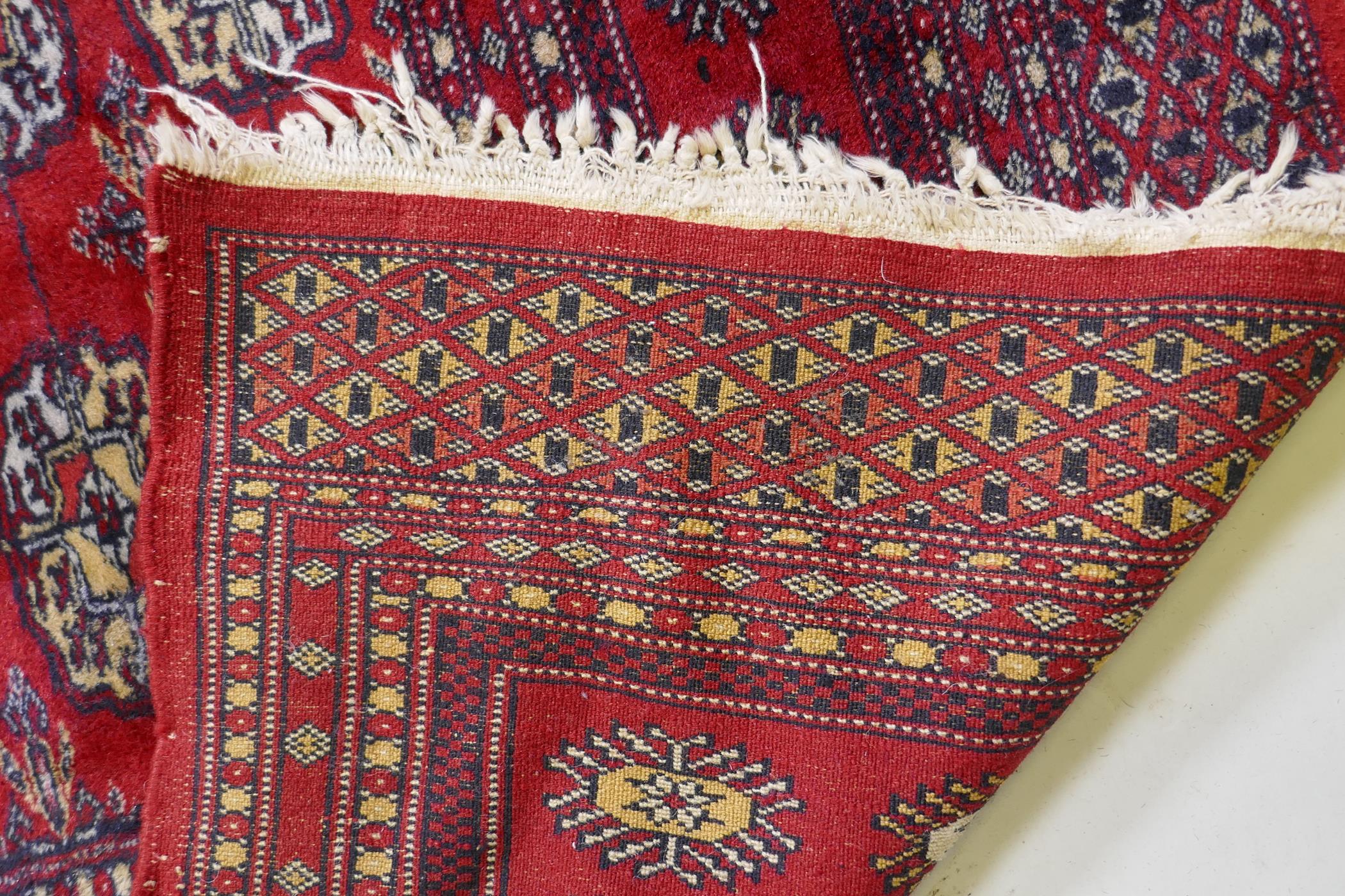 A fine woven red ground wool Bokharra rug, AF, 128 x 190cm - Image 4 of 7