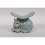 A Chinese ru ware style porcelain pillow, the base in the form of a temple lion, 11cm high