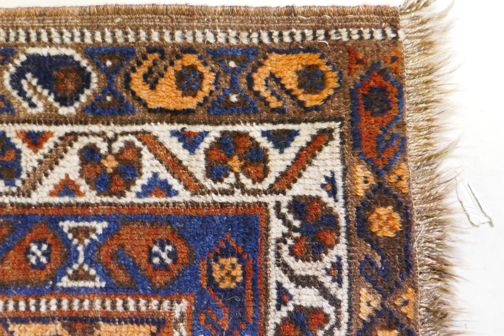 An antique terracotta ground Persian wool village rug, with a twin geometric medallion design, AF, - Image 4 of 5