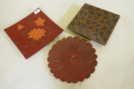 Three oriental carved and lacquered dishes with lotus and chrysanthemum decoration, marked to the