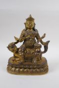 A Sino Tibetan gilt bronze figure of an armoured deity, seated on a kylin, 22cm high