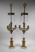 A pair of painted and gilt white metal three branch table lamps converted to electricity, 84cm high