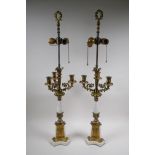 A pair of painted and gilt white metal three branch table lamps converted to electricity, 84cm high