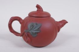 A Chinese YiXing pottery teapot in the form of a gourd, with a branch handle and leaf spout,