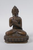 A Sino Tibetan filled bronze figure of Buddha seated on a lotus throne, mark to base, 14cm high