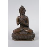 A Sino Tibetan filled bronze figure of Buddha seated on a lotus throne, mark to base, 14cm high