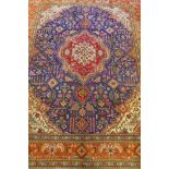 Large Persian carpet on a rich blue ground and multicolour field, with burnt orange border,