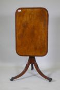 A Georgian mahogany tilt top table with crossbanded top, turned column and reeded supports, 73 x