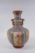 A Chinese polychrome porcelain two handled vase with decorative panels depicting birds,