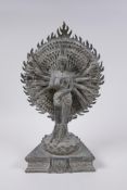 A Tibetan bronze figure of a many armed deity standing on a lotus flower, with verdigris patina,
