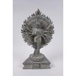 A Tibetan bronze figure of a many armed deity standing on a lotus flower, with verdigris patina,