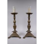 A pair of antique bronze candlesticks, converted to electricity, 43cm high