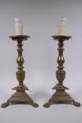 A pair of antique bronze candlesticks, converted to electricity, 43cm high