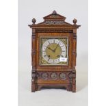 A C19th oak cased mantel clock with brass mounts and Gothic style decoration, the brass dial with