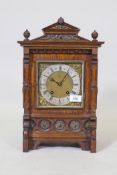 A C19th oak cased mantel clock with brass mounts and Gothic style decoration, the brass dial with