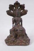 A Sino Tibetan gilt bronze figure of Buddha backed by a five headed cobra, mark to base, 27cm high
