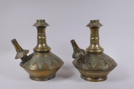 A pair of Indo Persian bronze hookah pipes with raised floral decoration, AF, 25cm high