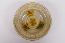 A Chinese celadon glazed pottery bowl with sancai details, 11cm diameter
