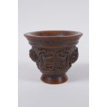 A Chinese faux horn libation cup with raised kylin decoration, seal mark to base, 8cm high x 10cm