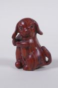 A Japanese carved wood netsuke in the form of a dog, signed, 5cm high
