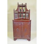 A Victorian mahogany standing corner cabinet with mirrored back and galleried shelves over two