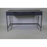 A contemporary two drawer desk with hinged flap and trunking holes for a PC, 132 x 60 x 76cm