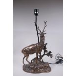 A bronzed composition lamp in the form of a stag, 62cm high without shade