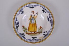 An C18th Italian majolica dish decorated with a lady in yellow, label to base, 23cm diameter