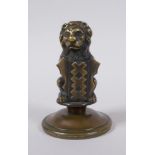 A bronze heraldic mount in the form of a lion with a shield, 10cm high