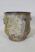 A C19th brass peat bucket with two lion mask handles, a gadrooned base and repousse heraldic