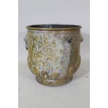 A C19th brass peat bucket with two lion mask handles, a gadrooned base and repousse heraldic