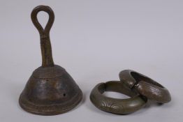 An African Benin bronze bell and two bronze cash bangles, 11cm high