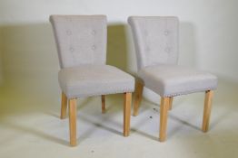 A pair of contemporary button back side chairs, raised on square tapering beechwood supports