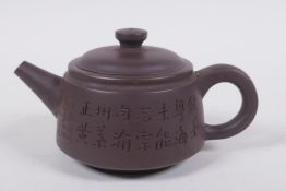 A Chinese YiXing pottery teapot decorated with a character inscription to side, impressed marks to