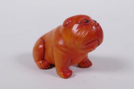 A Japanese carved boxwood netsuke in the form of a puppy, mark to base, 6cm long