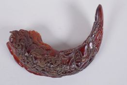 A Chinese carved horn decorated with carp in a lotus pond 21cm wide