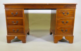 A yew wood five drawer pedestal desk with leather inset top, raised on bracket supports, 122 x 61