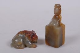 A Chinese mottled celadon and red jade carved temple lion together with a jade seal, the mount